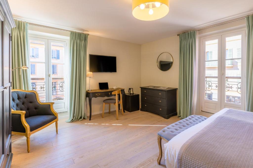 瓦尔邦讷阿尔莫里酒店的一间卧室配有一张床、一把椅子和一张书桌