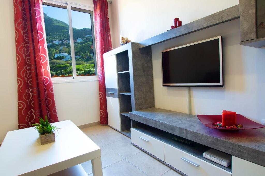 拉拉古纳F&M 'con terraza y tranquilidad'的客厅配有平面电视和桌子。