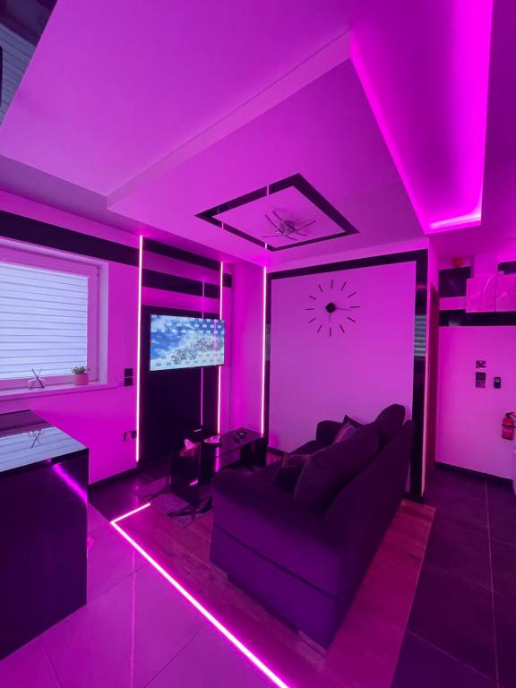 阿斯隆#5 TGHA Luxury One Bedroom Apartment in Athlone的客厅配有粉色灯光和沙发
