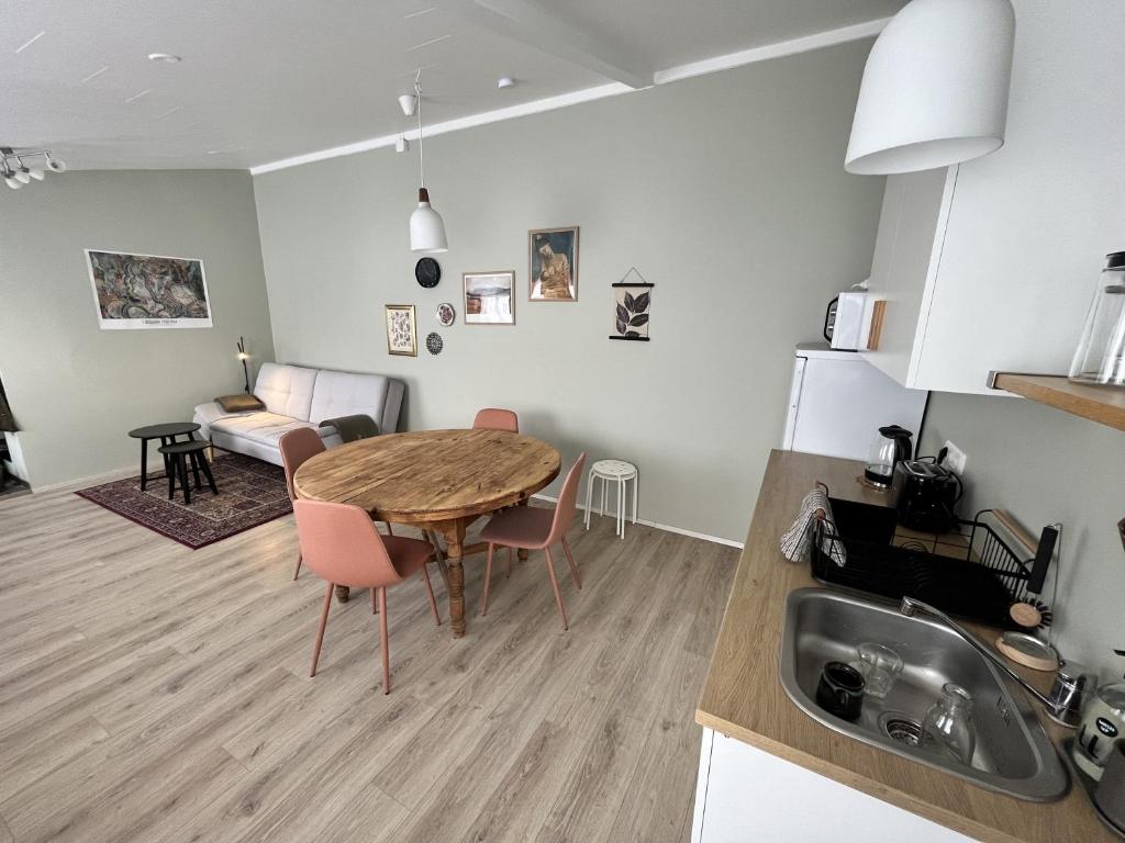埃基斯蒂尔Bridge Apartment的厨房、带木桌的客厅和用餐室