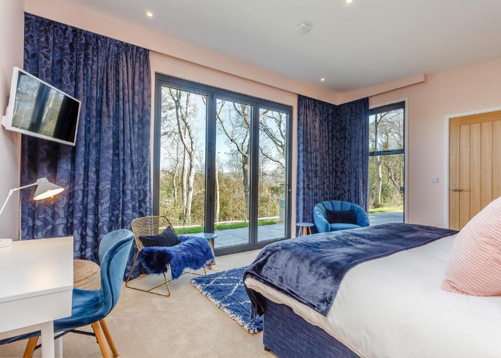 刘易斯Swanborough Lakes的一间卧室设有一张床和一个大窗户