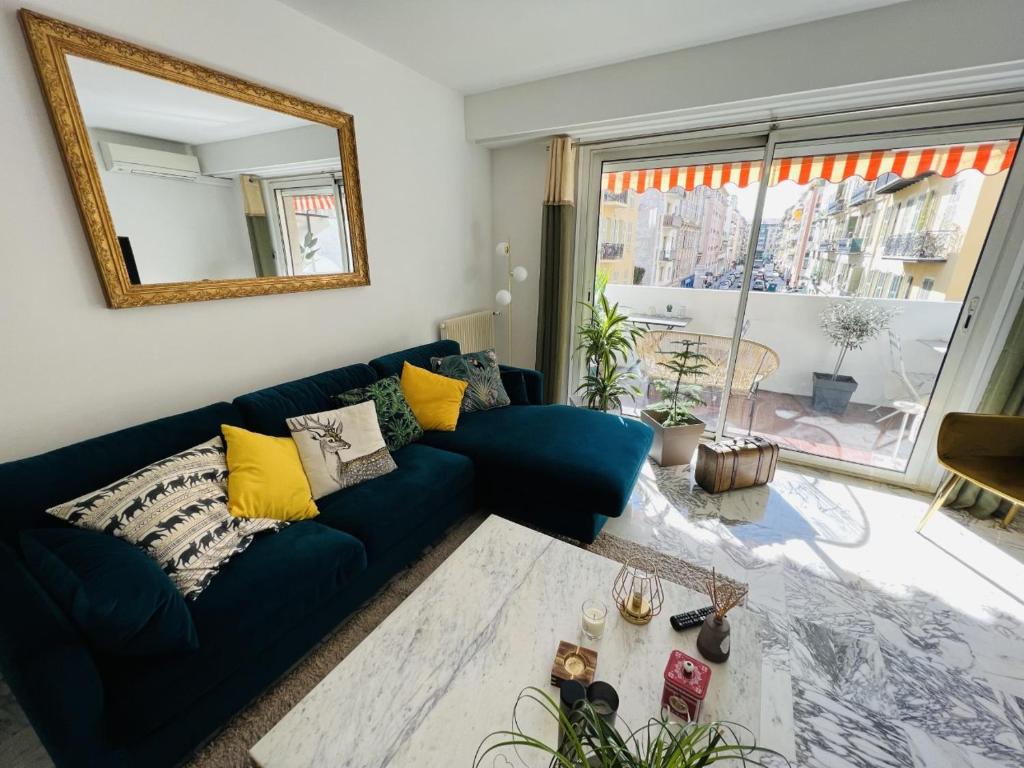尼斯John Homestay Room in Nice的客厅配有蓝色的沙发和镜子