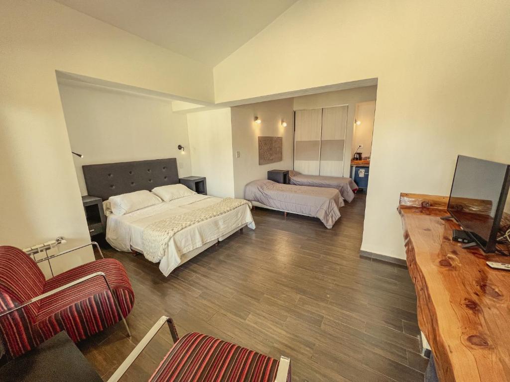 韦尔塔格兰德Estancia Alto San Pedro的一间卧室配有一张床、一张沙发和一台电视