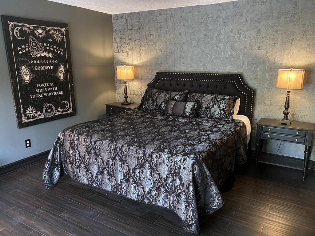 坦帕Phantom History House - Ouija Room的一间卧室配有一张床和两个带灯的床头柜