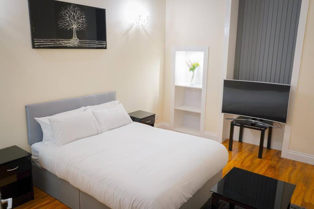 格拉斯哥Glasgow - 2 Bedroom Apartment的卧室配有白色的床和平面电视。