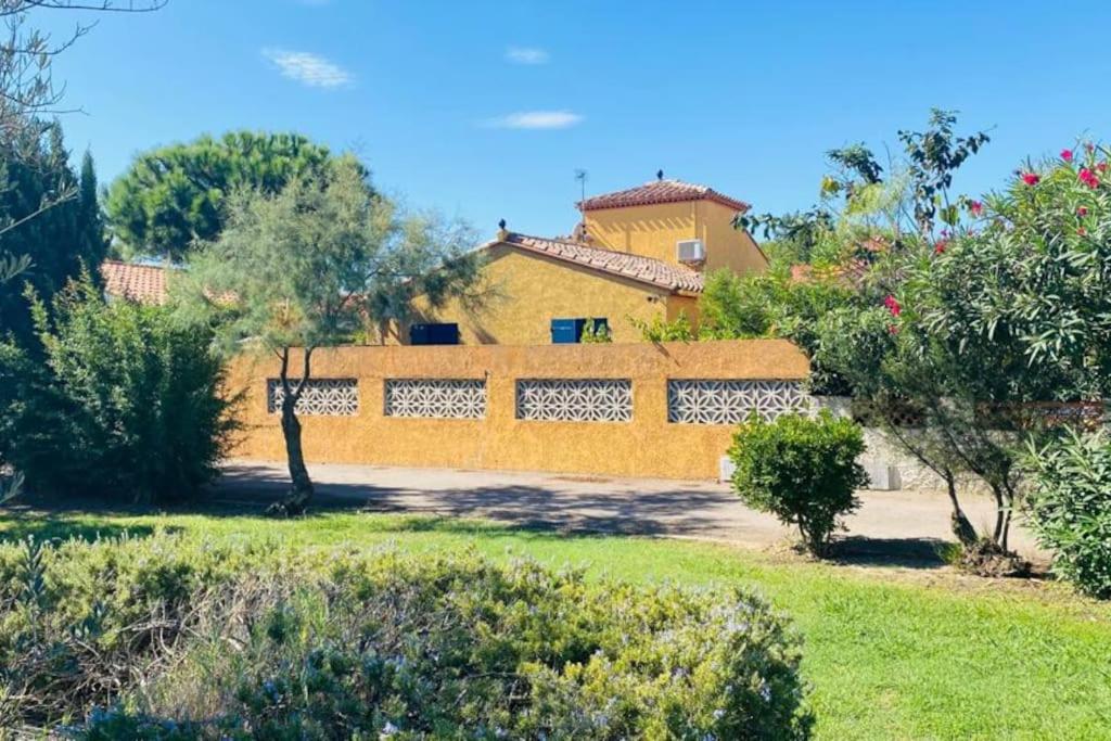 乐巴凯尔斯Magnifique Maison avec piscine privée à 300 m d&#39;une trés jolie plage de sable的前面有院子的黄色房子