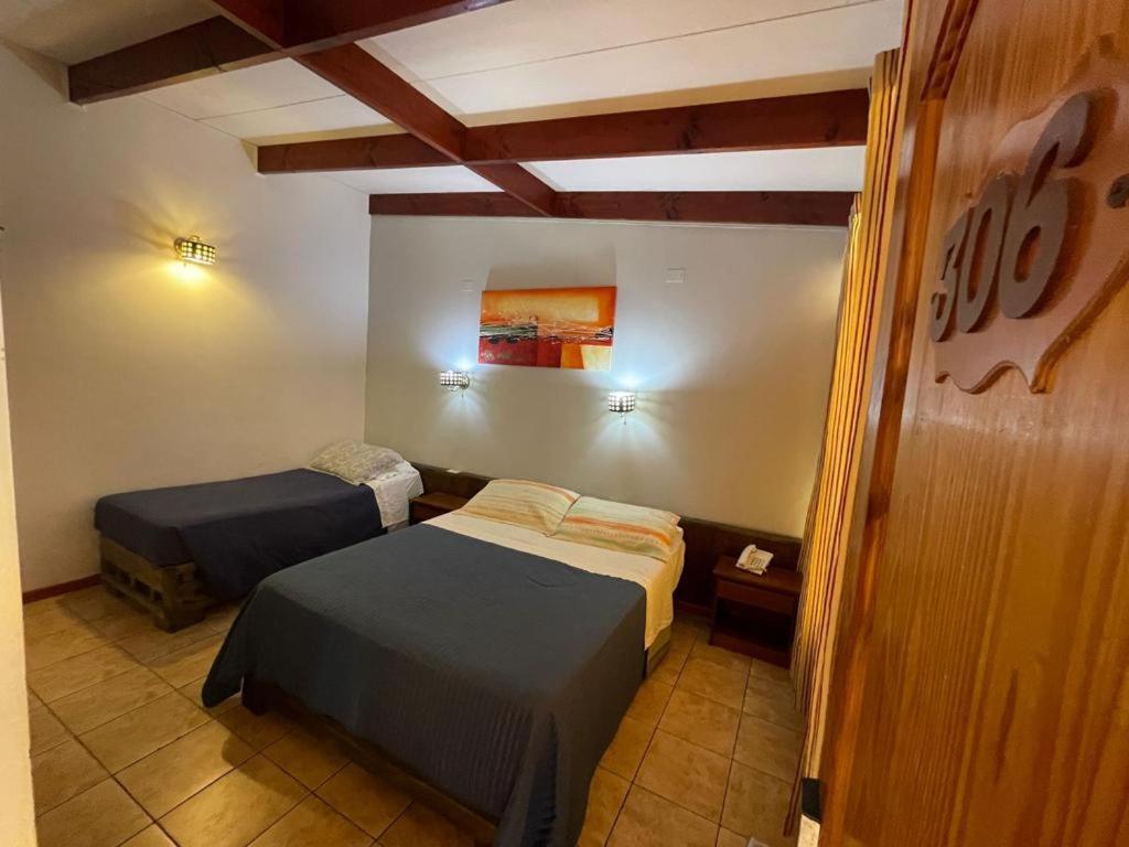 阿里卡科隆广场酒店的一间卧室,配有两张床
