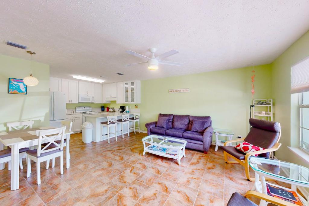 巴拿马城海滩Wendwood Condominiums F2的一间带紫色沙发的客厅和一间厨房