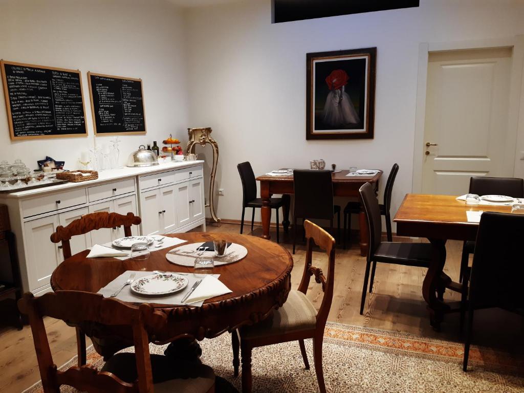 特伦托B&B S. Trinità 18 Suites & Rooms的一间带桌子和桌椅的用餐室