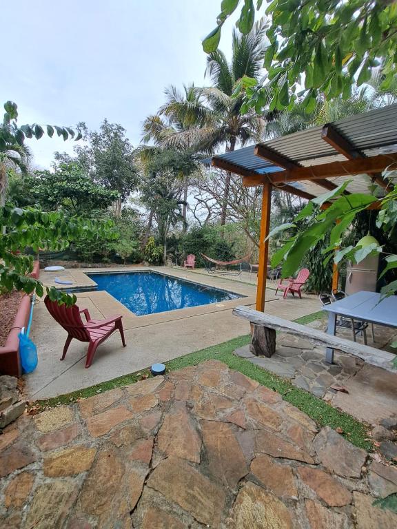 奥科塔尔Guesthouse Casa Avi Fauna的一个带红色椅子和野餐桌的游泳池
