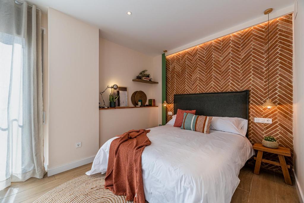 坎布里尔斯Vestal Suites Domo的一间卧室配有一张大床和大床头板