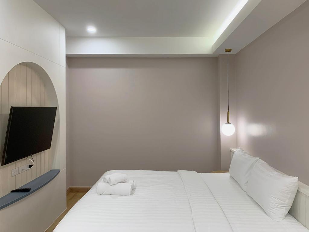 帕卡农区Moon House BKK Room 3B的一间白色卧室,配有床和电视