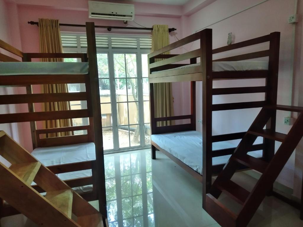 尼甘布Cross Ceylon的客房设有两张双层床和一扇窗户。