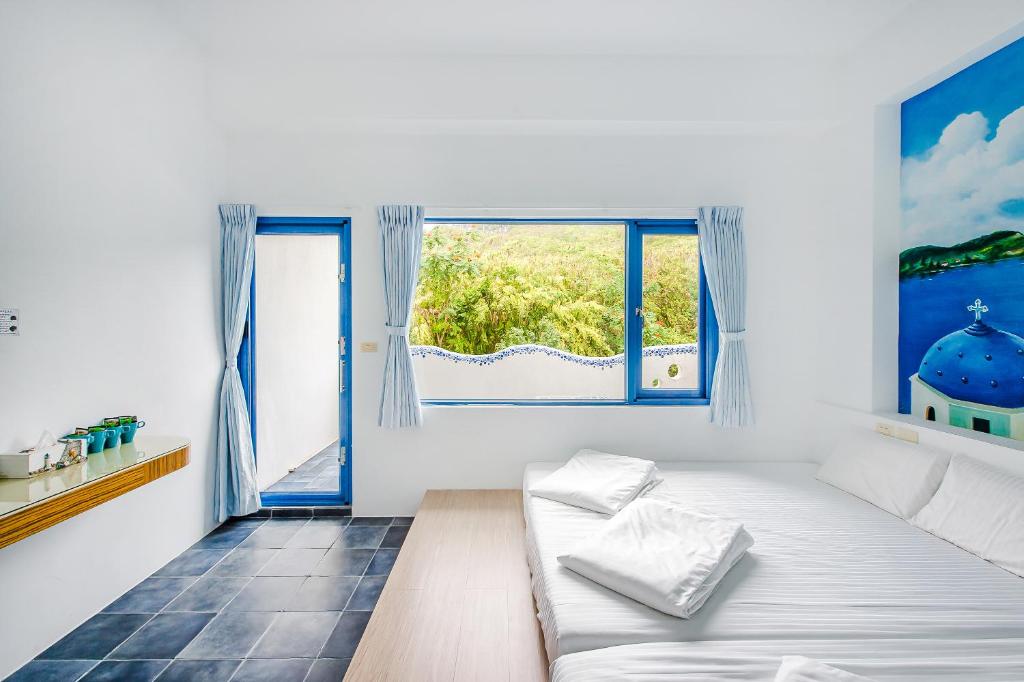 小琉球岛白灯楼旅宿的白色的客房设有床和窗户。