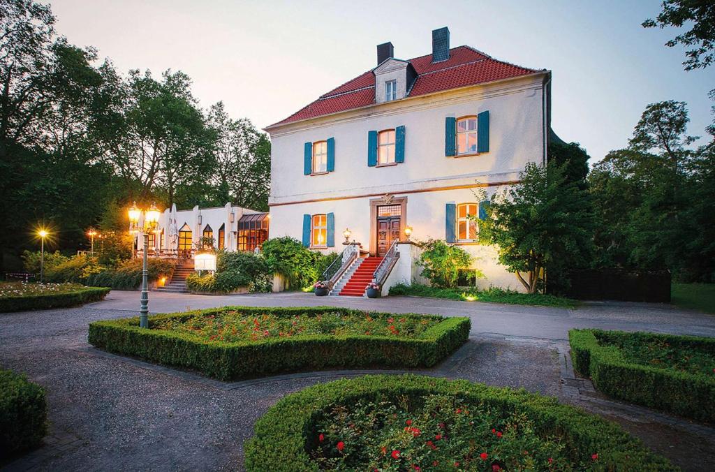 卡斯特罗普-劳克塞尔Vienna House Easy by Wyndham Castrop-Rauxel的一座大型白色房屋,设有红色屋顶