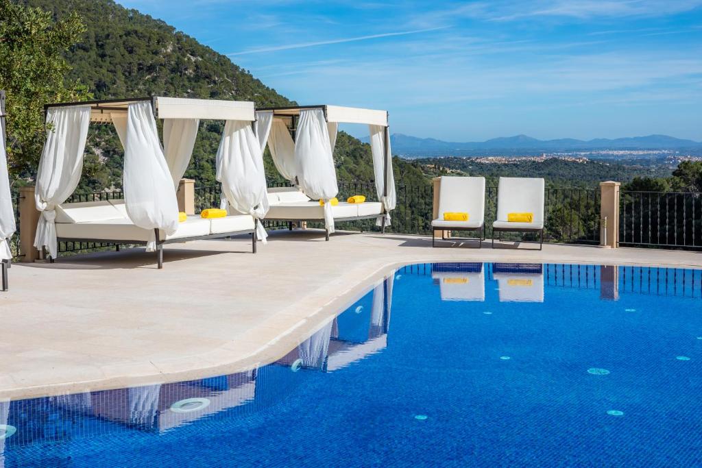 比尼博纳Finca Albellons的度假村的游泳池设有白色椅子,享有美景
