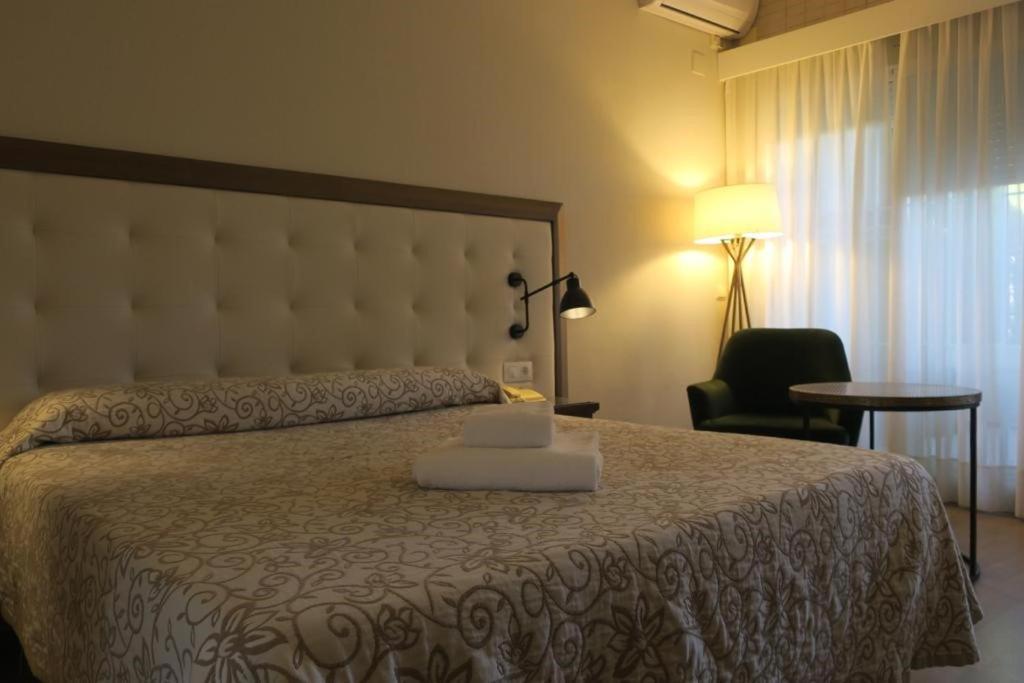 卡耐特蒂贝兰格卡内特普拉亚酒店的一间卧室配有一张带笔记本电脑的床