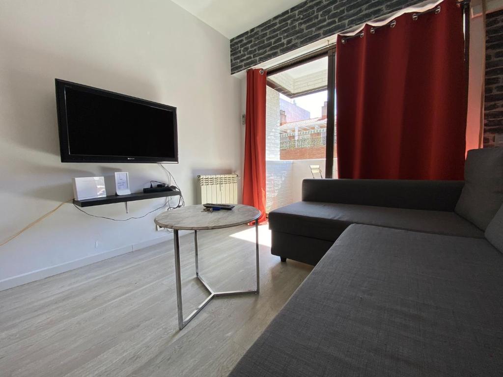 马德里Apartamento Cuzco的带沙发、电视和桌子的客厅