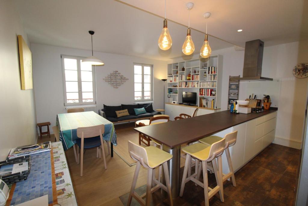 圣让-德吕兹GAMBETTA AVEC LES CLES DE LUZ的厨房以及带桌椅的起居室。
