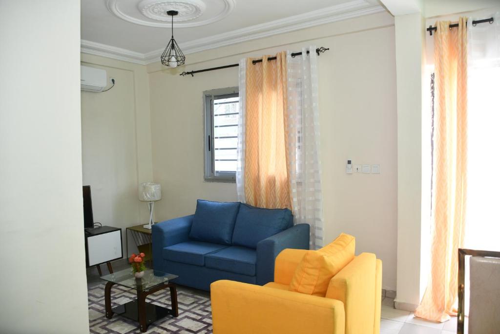 杜阿拉Spetiv Guesthouse的客厅配有蓝色的沙发和黄色的椅子