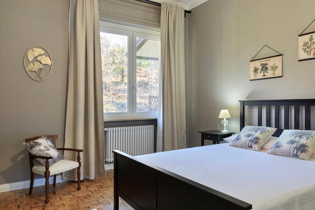 Fara NovareseVilla Caramino的卧室配有床、椅子和窗户。