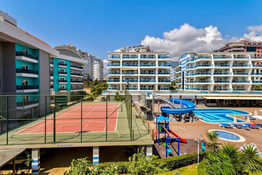 阿拉尼亚SA Apartments! Crystal Family Suites的一座有建筑物的城市的网球场