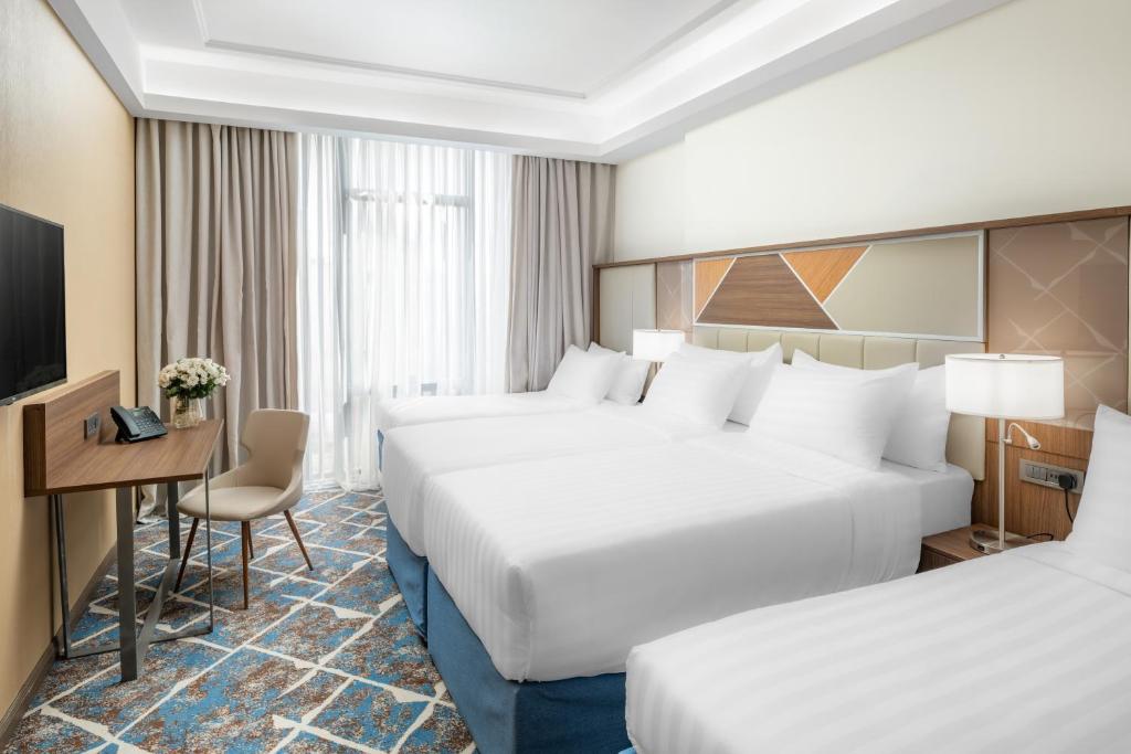 麦加Three Points Musalli Makkah的酒店客房配有两张床和一张书桌