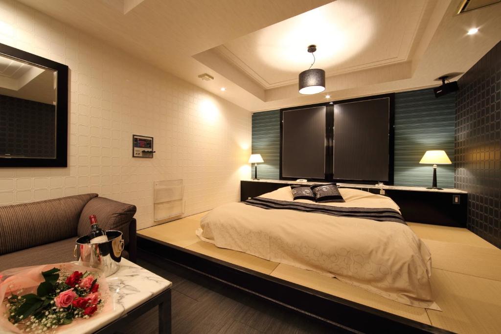 京都Hotel La Siesta (Adult Only)的一间卧室配有一张大床和一张沙发