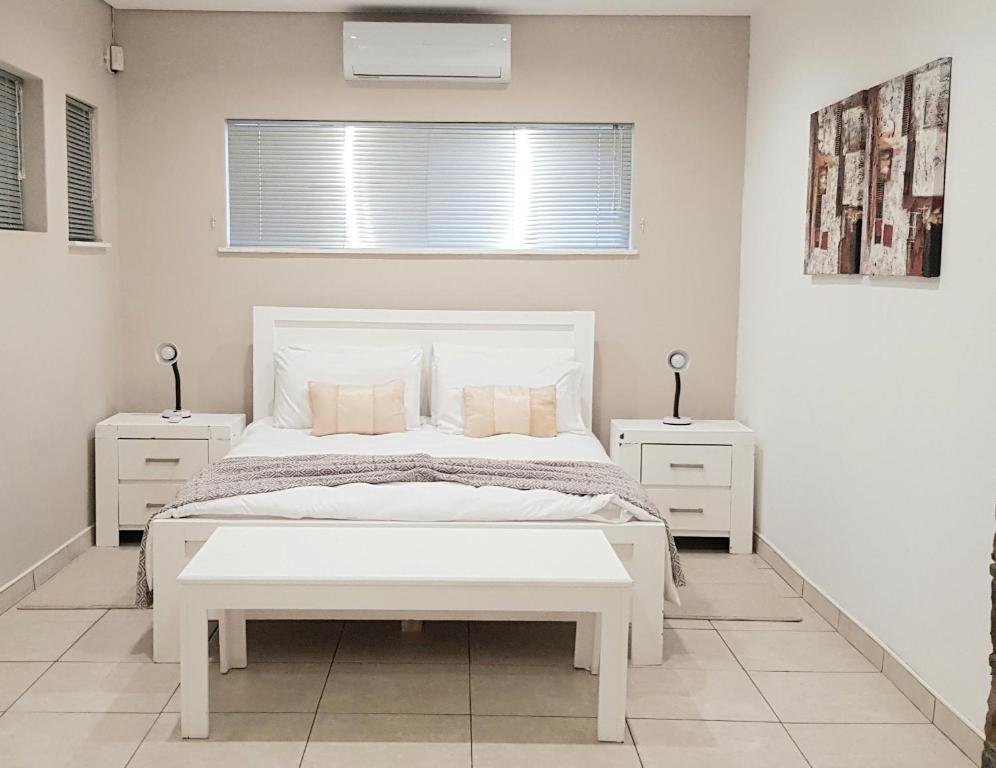 温特和克Feather Self Catering Accommodation的白色卧室,配有白色的床和2个床头柜