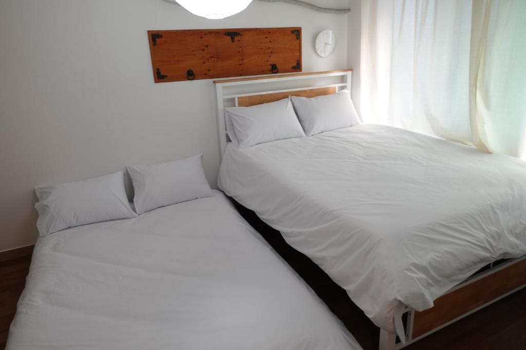 首尔Hostel JL in Chung-jeong的一间卧室设有两张床和窗户。
