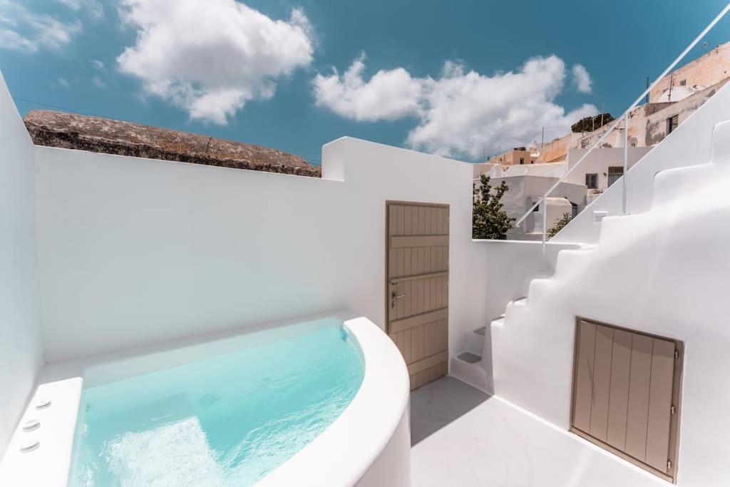 安坡里奥圣托里尼AKRI santorini with heated jacuzzi的白色的房子,设有游泳池和楼梯