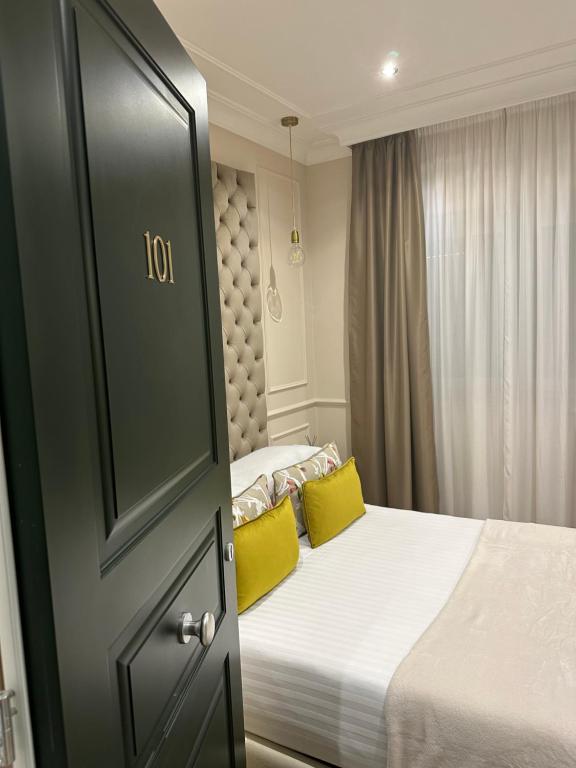 罗马NLM Boutique Suites的一间卧室配有一张带两个黄色枕头的床