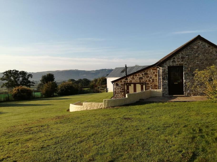 卡马森The Barn.的一块石头建筑,在田野上有一扇门