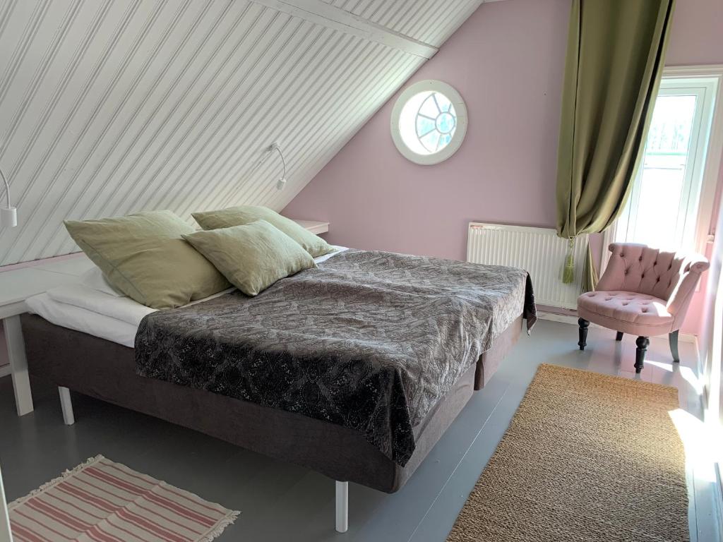 LöderupStrandbadsgården B&B的一间卧室设有一张床、一个窗口和一把椅子