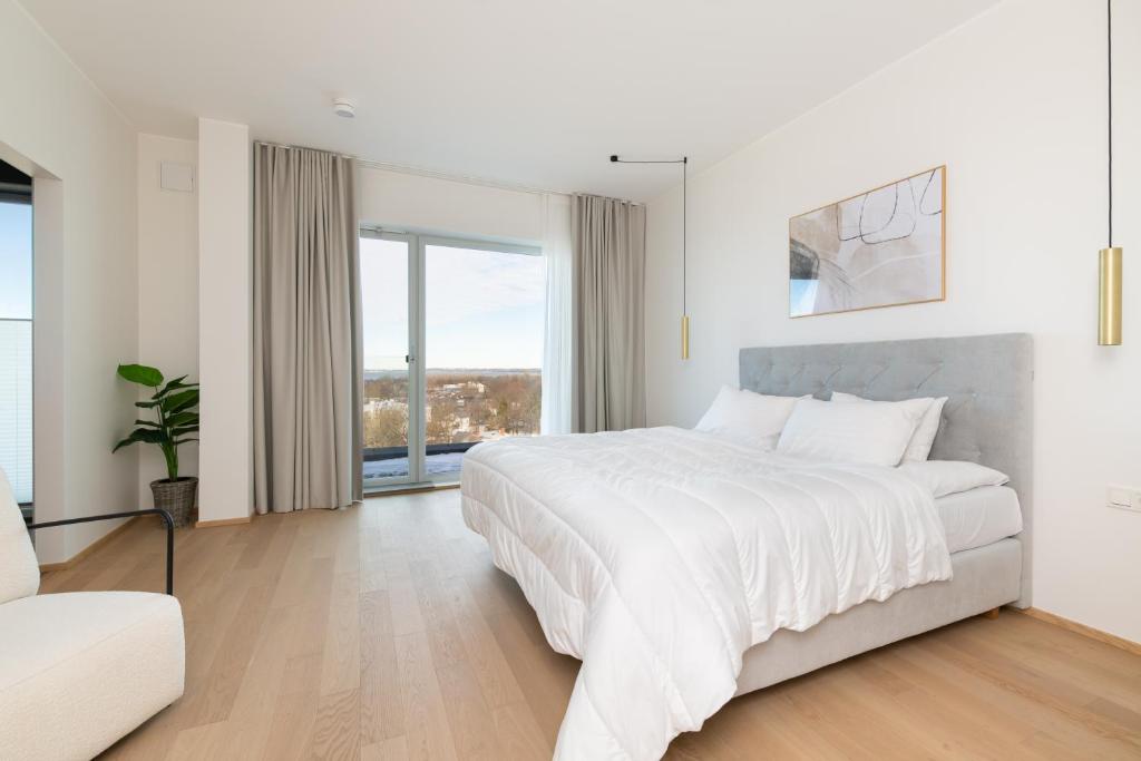 塔林4bdr Modern and Stylish Apartment near Kadriorg with Free Parking的白色卧室设有一张大床和一张沙发