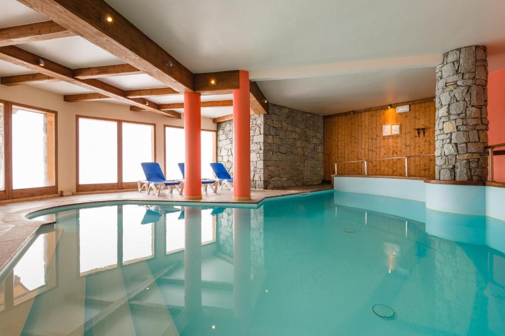 佩塞克鲁瓦拉格朗日拉罗拉瑞假日公寓式酒店的一座带蓝色椅子的建筑中的游泳池
