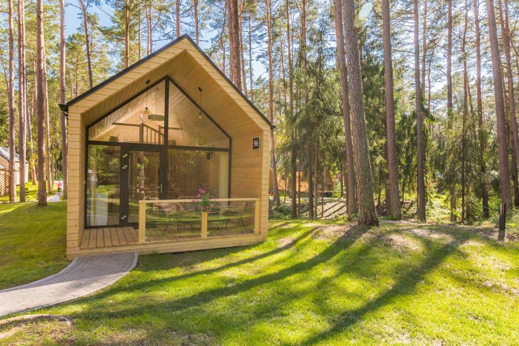 斯图托沃BURSZTYNOWO Ośrodek Wczasowy的树林中一个小房子,有大窗户