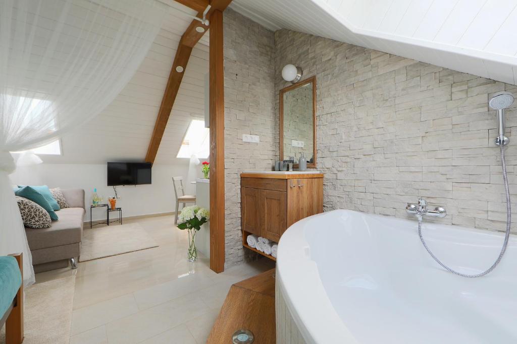 巴拉顿菲赖德Lotti Residence Romantik的带浴缸的浴室和客厅。