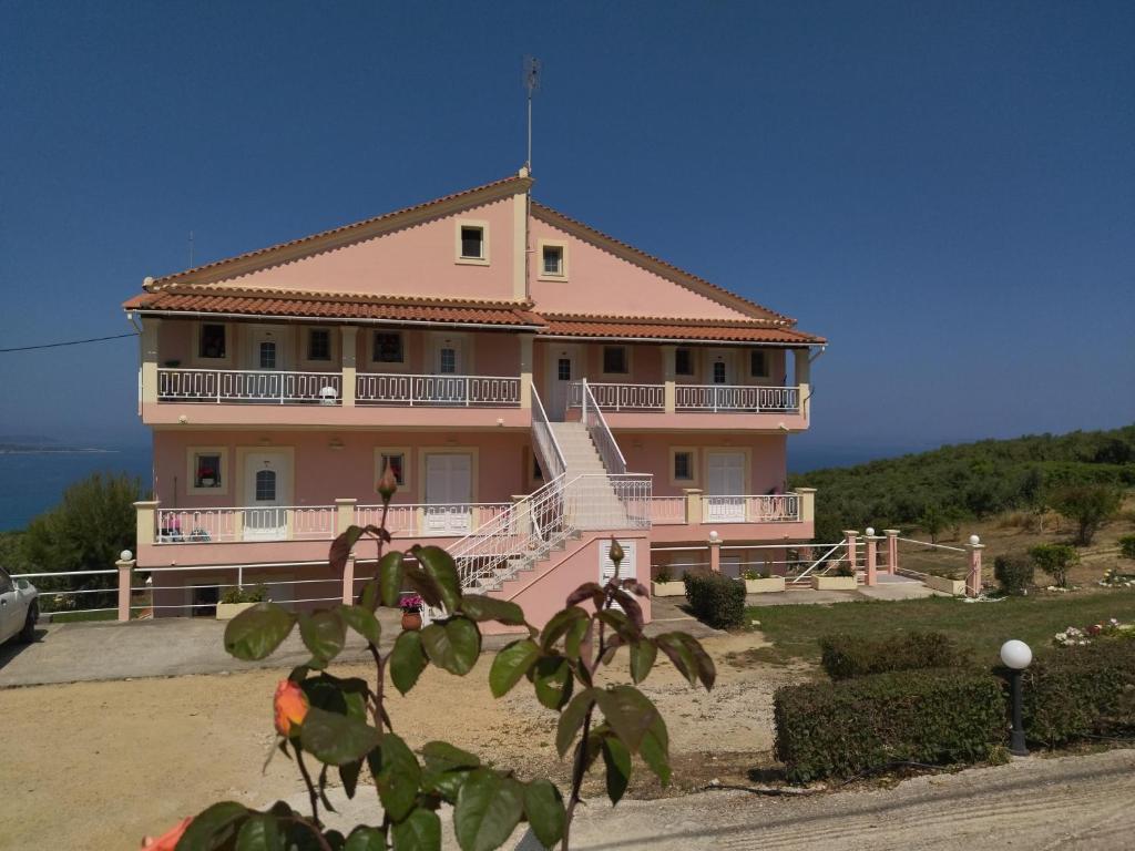圣斯特凡诺斯Panorama View的一座位于山丘上的大型粉红色房屋,设有阳台