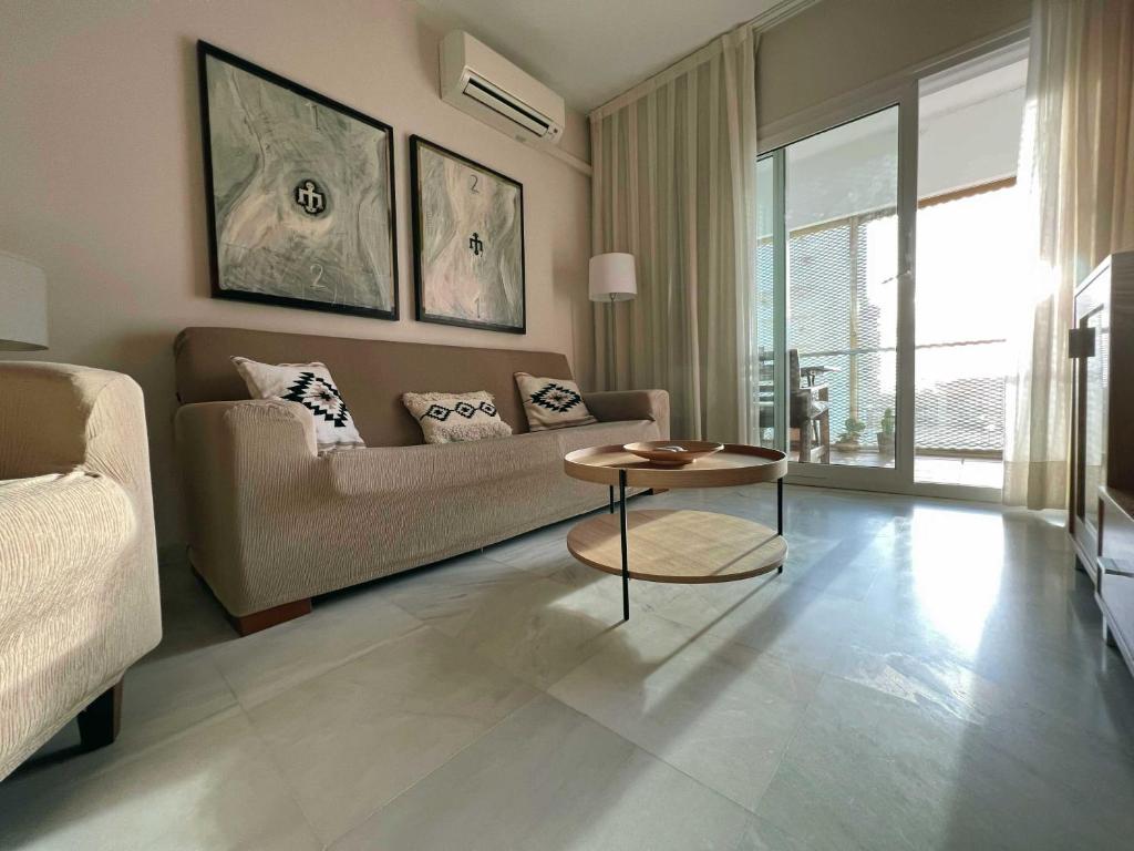 圣玛丽亚港Apartamento en la playa de Valdelagrana的客厅配有沙发和桌子
