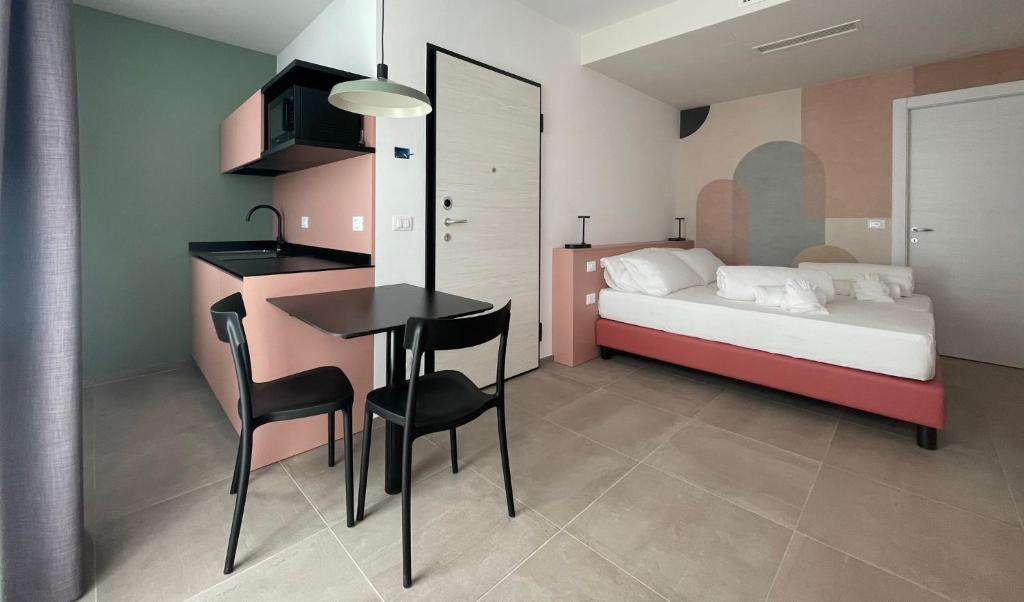 阿科Arqué Apartments - Arco Centro的卧室配有一张床和一张桌子及椅子