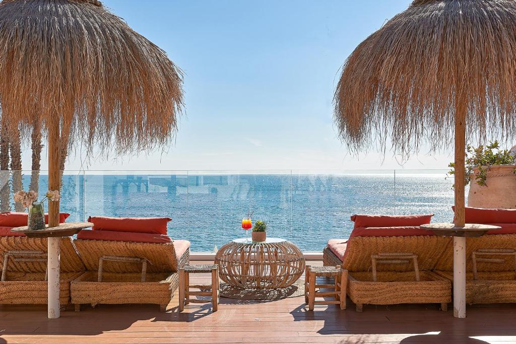 马拉加Suite Deluxe Face Mer Apart Malaga的一个带桌椅的庭院,享有水景