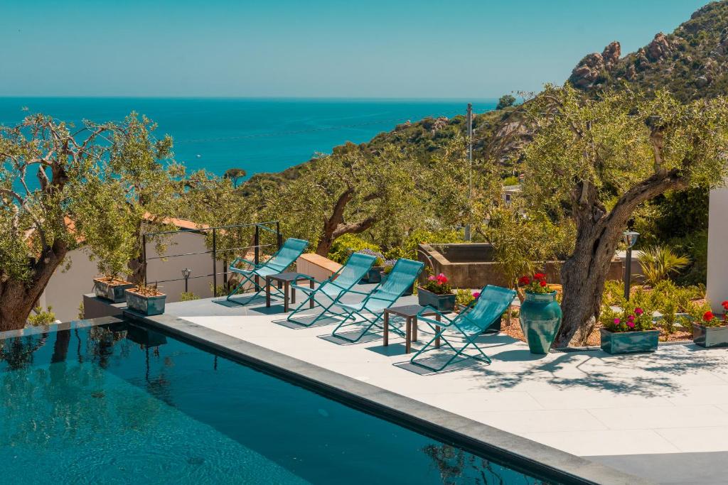 切法卢Villa Totò Resort的一个带椅子的游泳池,背景是大海