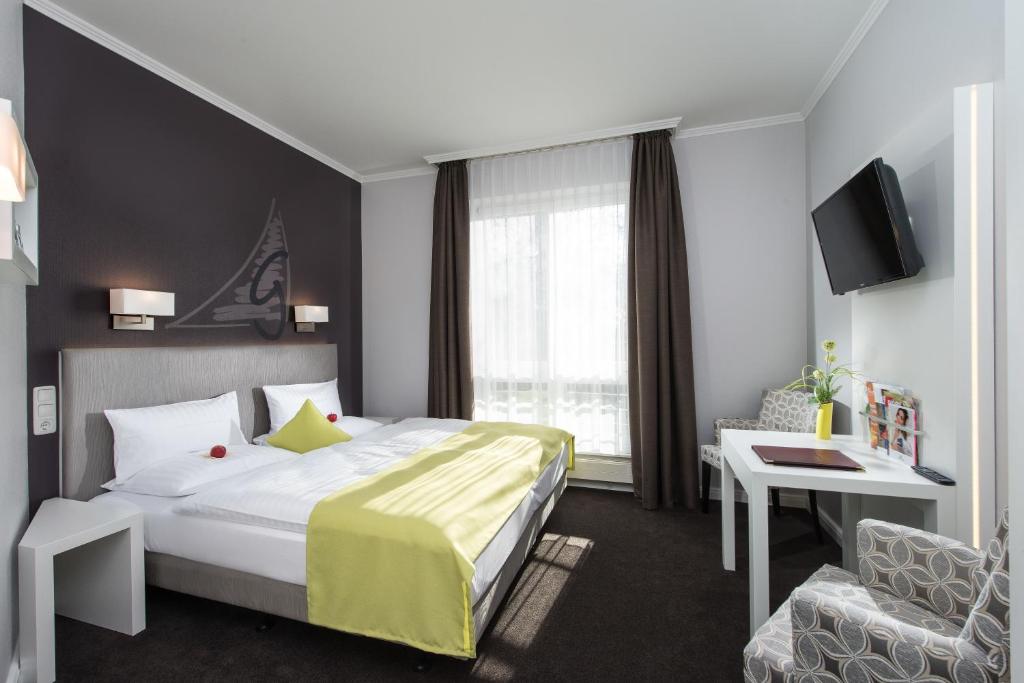 瓦尔内明德戈德温酒店的酒店客房设有一张床、一张书桌和一台电视机。
