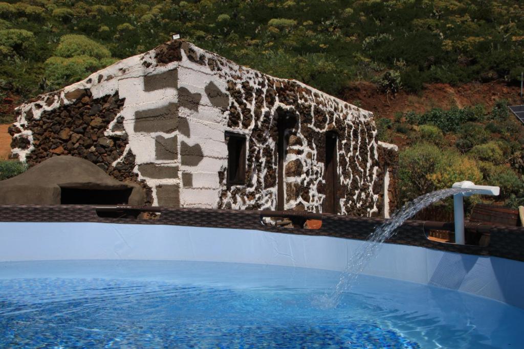 巴尔韦尔德La Chusmita的一座石头建筑,在游泳池里设有喷泉