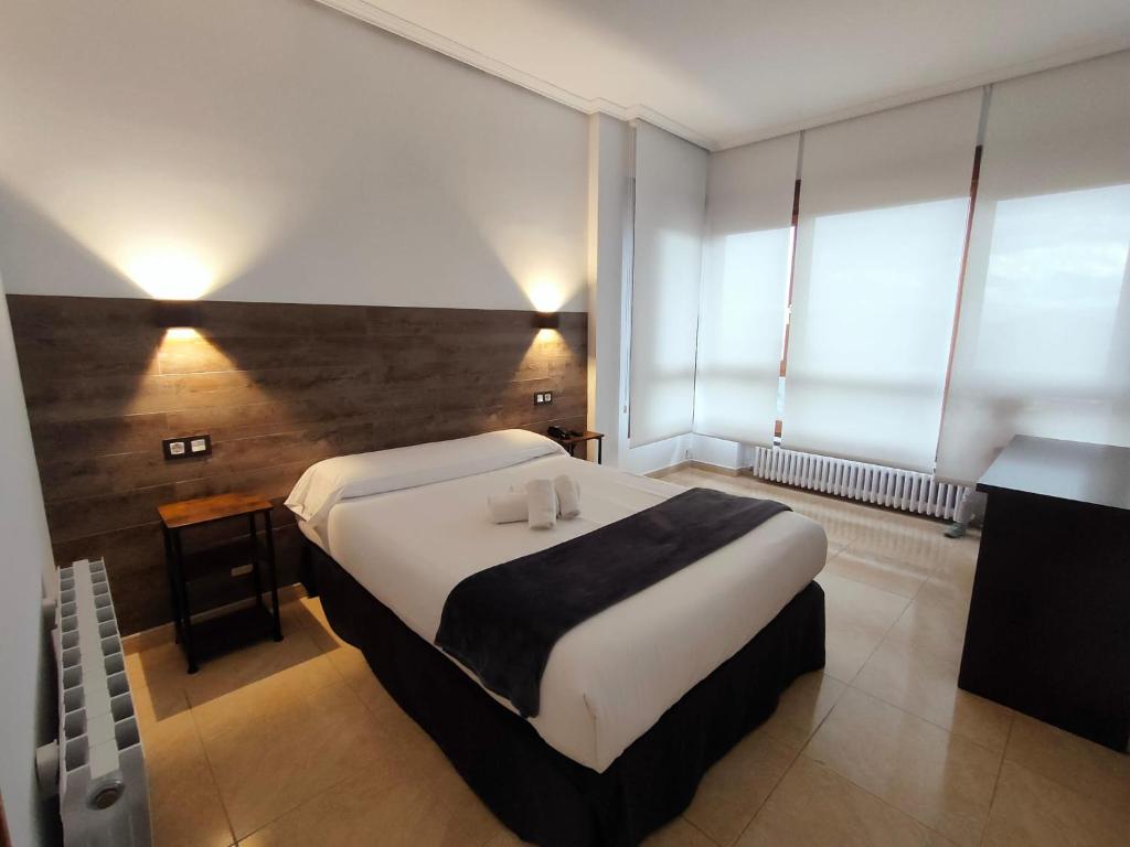 毕尔巴鄂Hotel Artxanda Bilbao的一间卧室配有一张大床,上面放有两根蜡烛