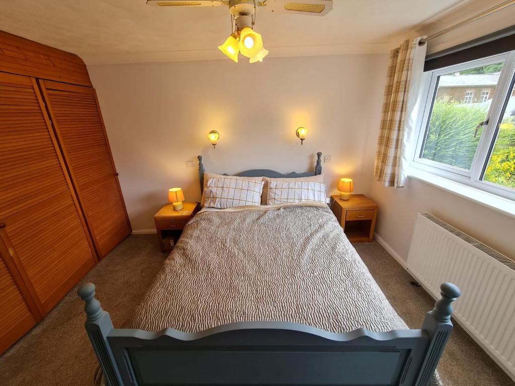 North RunctonRycroft的一间卧室配有一张床,两台桌子上放着两盏灯