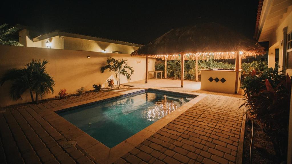 棕榈滩Dushi Villa的夜间在房子前面的游泳池