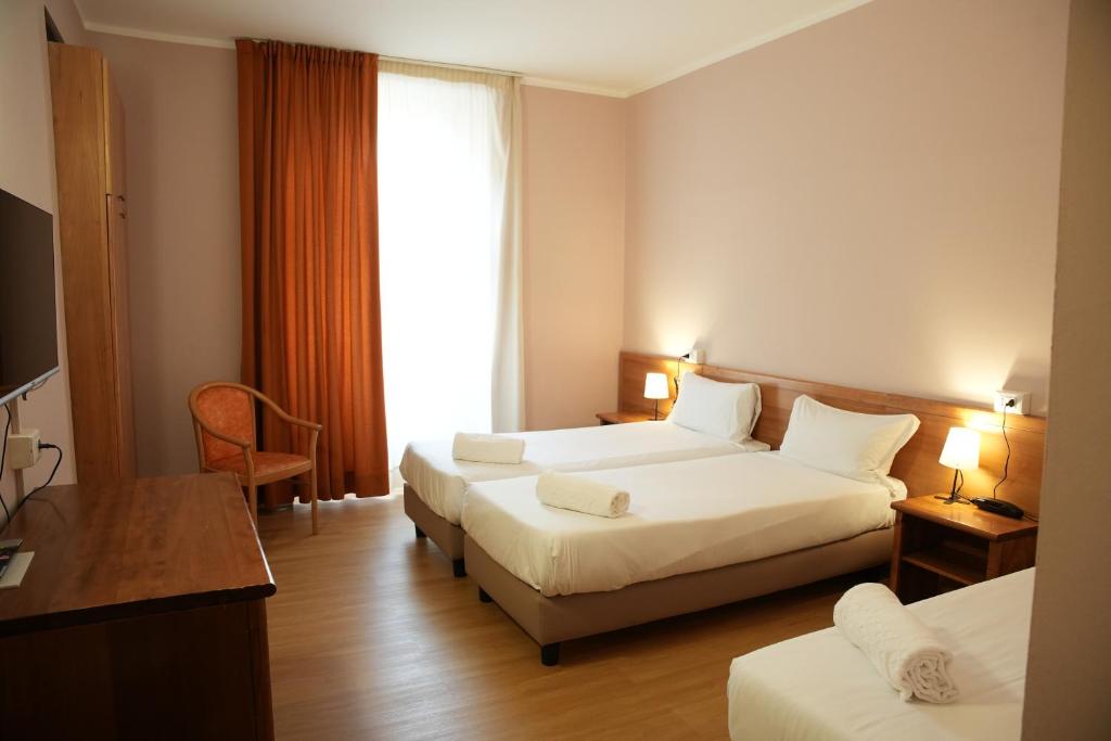 都灵Hotel Montevecchio的酒店客房设有两张床和窗户。