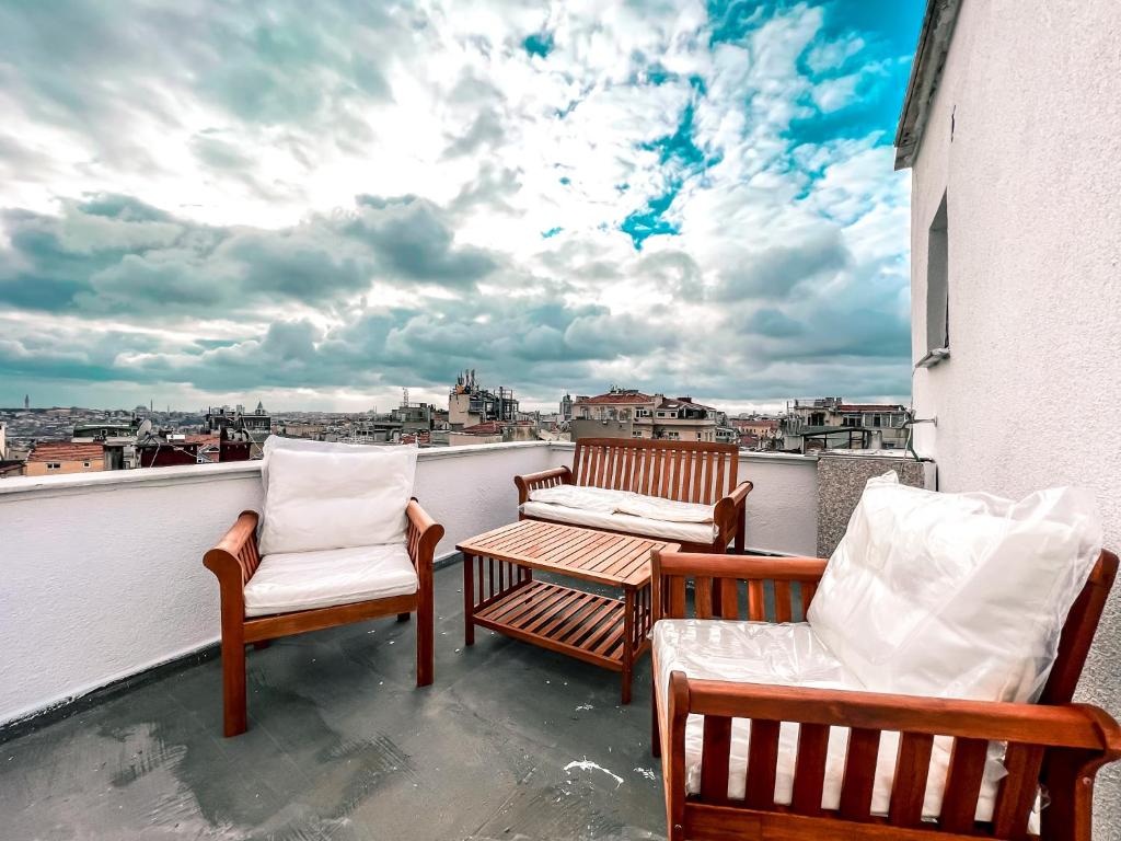 伊斯坦布尔Cihangir VAV Suites的美景阳台配有三把椅子和一张桌子